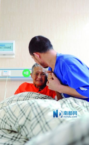 4月3日下午,东莞市厚街医院。历经“生死”,母子二人抱头痛哭后,杨秀为母亲按摩。南都记者 梁清 摄 4月3日下午,东莞市厚街医院。历经“生死”,母子二人抱头痛哭后,杨秀为母亲按摩。南都记者 梁清 摄