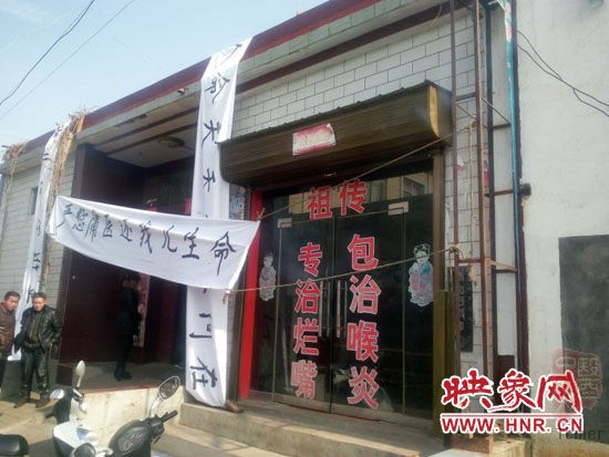 诊所大门口已被洋洋的家属挂满了纵横交错的白色横幅 诊所大门口已被洋洋的家属挂满了纵横交错的白色横幅